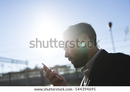 Young man talking to the cellphone, lens flare