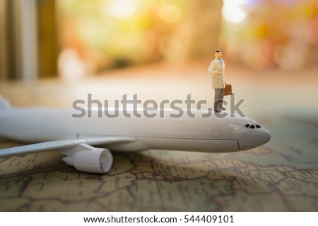 Miniature people : Businessman standing on airplane using as background travel or business concept.