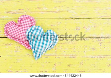 Romantic greeting card with two fabric hearts in pink and blue.