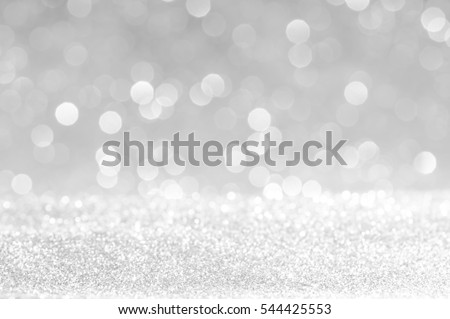 silver Sparkling Lights Festive background with texture. Abstract Christmas twinkled bright bokeh defocused and Falling stars. Winter Card or invitation.