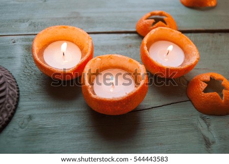 candle and tangerines on a wooden table