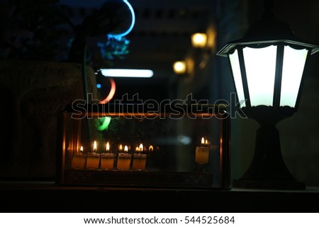 A family is lighting a candle for the Jewish holiday of Hanukkah that is observed for eight nights and days.
Beautiful lit hanukkah menorah on black background.
 the Jewish Festival of Lights



