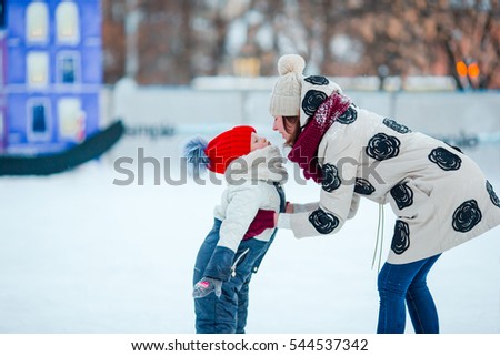 Portrait of little adorable girl and young mother skating