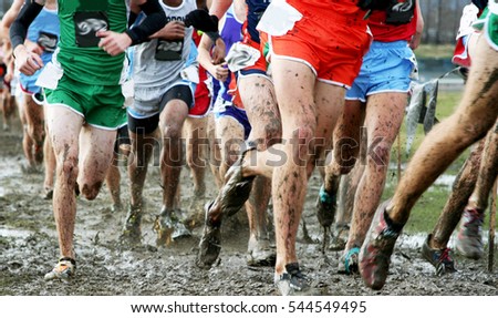 High school boys compete at the National cross country championships and race through the mud