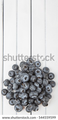 Blueberry fruits over white wooden background
