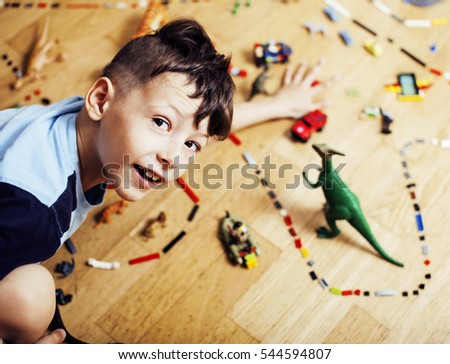 little cute preschooler boy among toys lego at home happy smiling, lifestyle people concept