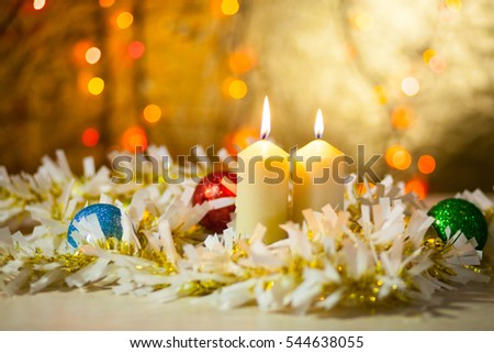 Two burning candles in a Christmas ornament with blurred background, bokeh