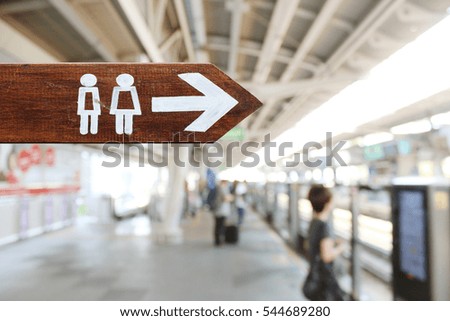 man and a lady toilet sign on wooden