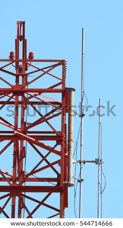 Telecommunication tower and red color and blue sky.