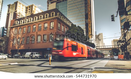 Red Trolley through the building from sidewalk street in downtown San Diego city, USA Royalty-Free Stock Photo #544731970