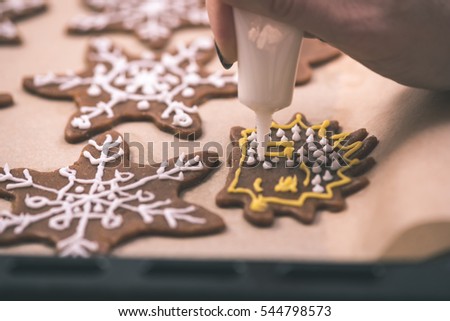 Womans hand decorating cookies with sugar. Making Gingerbread Cookies Series. - vintage effect