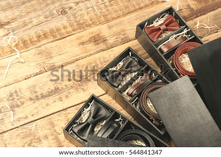 Luxury men outfits in black boxes on wooden background