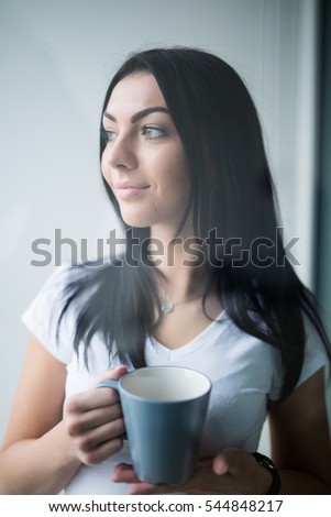 Woman with coffee cup in rest room at office