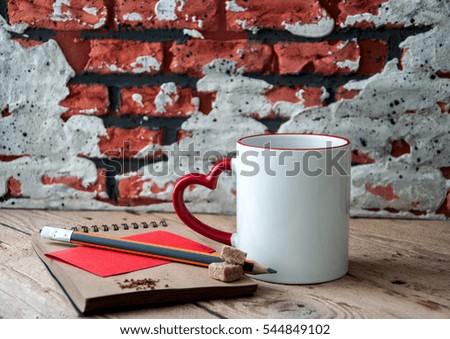 A big cup of coffee and craft paper note with a pencil and brown sugar on a wooden background