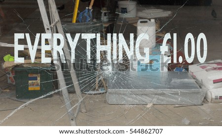 Broken shop window and discount sign, Bolton, UK 