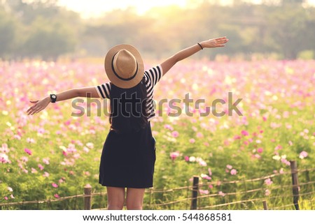 Beauty Girl Outdoors enjoying nature. Beautiful Teenage Model girl in black dress standing  on the Spring Field, Sun Light. freedom concept Royalty-Free Stock Photo #544868581