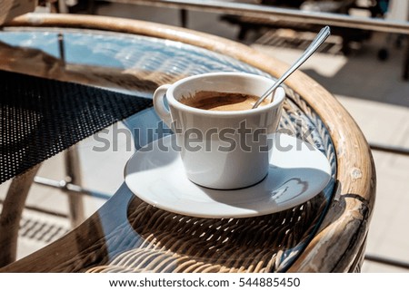 a cup of coffee on a glass table. summer cafe
