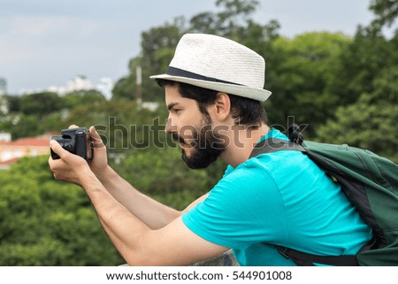 Young man taking photos at panoramic view of a city