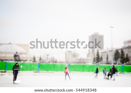 abstract background blur ice rink. people children are skating, relaxing and having fun on winter vacation