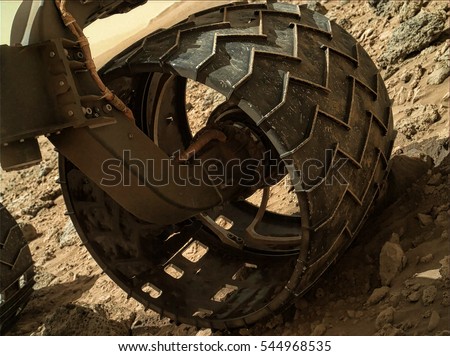Mars rover wheel on mars surface. Elements of this image furnished by NASA