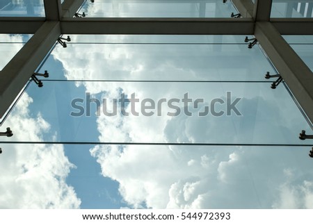 Dramatic clouds viewed through the window of a modern office building. View from below upwards 