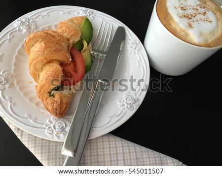 Coffee cup and fresh baked croissants on black background. Top View.