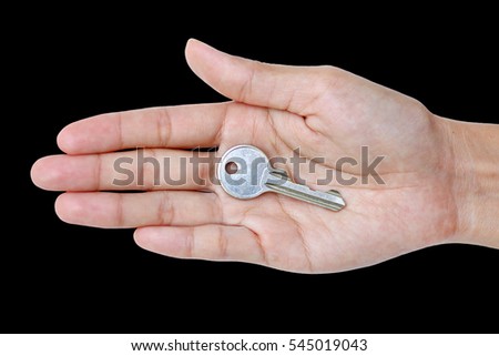 Closeup photo of hand holding keys isolated on black background