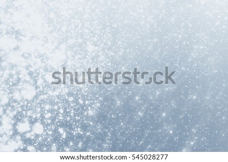 Snowflakes particles and white  bokeh or glitter lights on silver background. Christmas abstract template