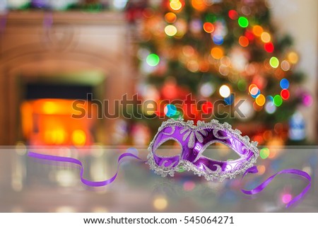 Carnival mask on a blurred background of Christmas tree and fireplace