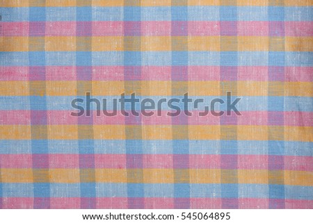 Linen fabric in squares scottish cute photo texture. Colorful blue pink orange plaid backdrop in squares photo Linen cloth fabric rhythm of squares. Vintage retro atmospheric decor. Cozy kitchen towel