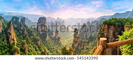 Zhangjiajie Forest Park. Panoramic view above the cliffs and mountains to the colorful valley at sunrise. Picturesque landscape. Majestic nature. Royalty-Free Stock Photo #545143390