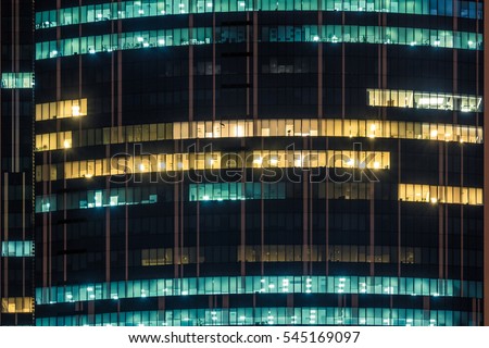Skyscraper windows glow at night. Modern office building at night