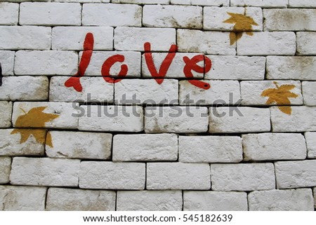 red love message with tree brown leafs on white wall in background