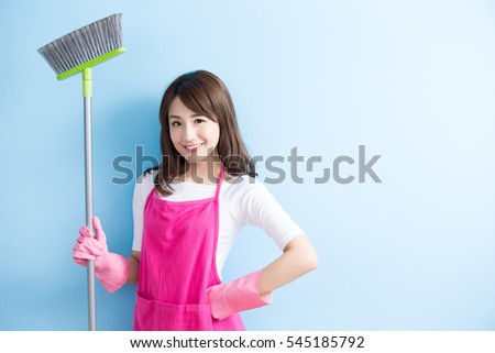 beauty housewife take broom and smile to you isolated on blue background,asian