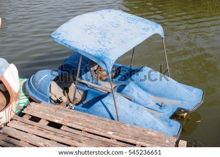 Pedal boat parking on a pier in a city park lake