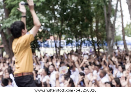 Concert in school with a lot of students clap their hand /A singer wears yellow shirt / Concept Blur picture
