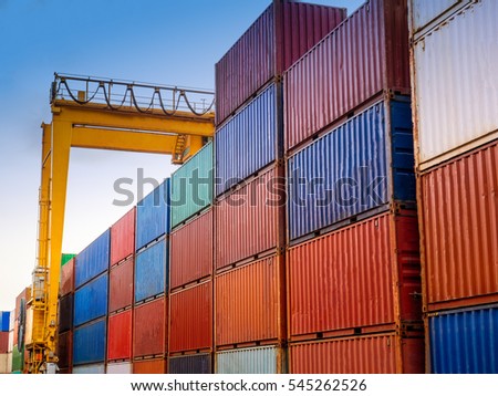 The RTG(Rubber Tried Gantry Cranes) is handling full loaded containers  at industrial port and container yard. Royalty-Free Stock Photo #545262526