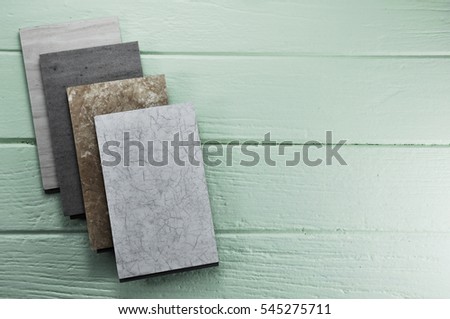A studio photo of laminate vinyl flooring on wooden background. Samples of laminate on wood background.