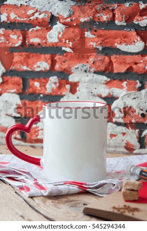 A big cup of coffee and craft paper note with a pencil and brown sugar on a wooden background
