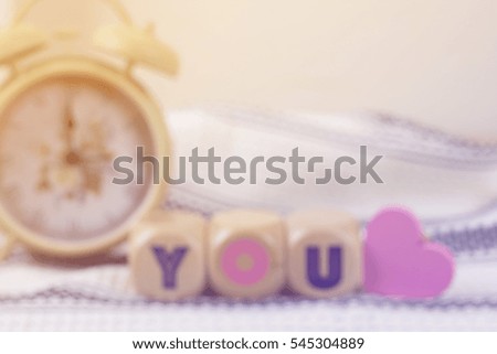  blurry picture of lovely wood blocks with vintage alarm clock for valentine background, filtered tones