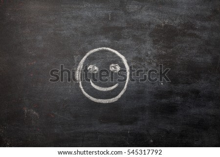 hand drawing smiley face on blackboard