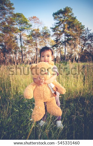 Classic color little girl alone with toy bear in the forest