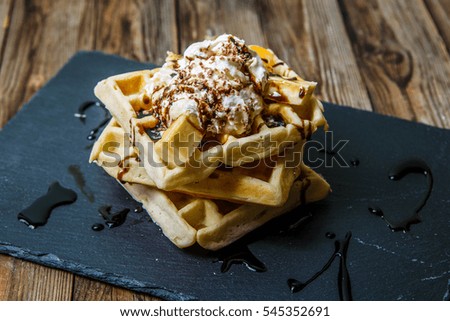 Picture of several Viennese waffles with chocolate, tangerines and ice-cream on blackboard