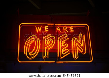 Open neon sign against dark background showing open for business
