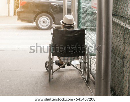 The patient sits on a wheelchair.