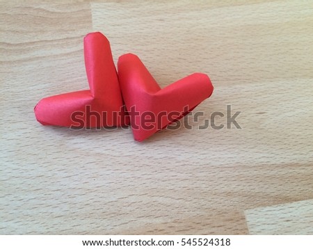 Two folding Paper Red hearts is isolated on wooden Background. You can use for greeting card (Happy Valentines Day)