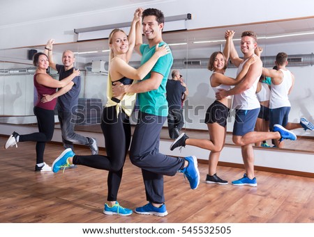Young men and women dancing the salsa o bachata in dance hall  Royalty-Free Stock Photo #545532505