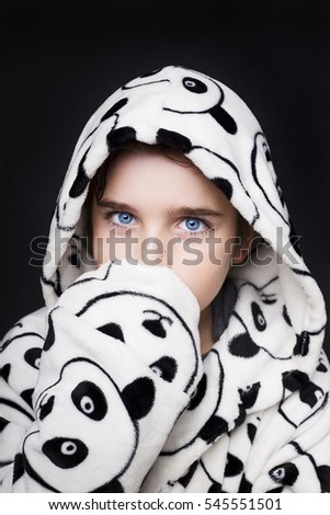 Portrait of a handsome boy in bathrobe Panda on a black background.