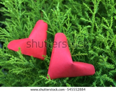 Two folding Paper Red hearts hanging on Green Branch trees Nature Background. You can use for greeting card (Happy Valentines Day)