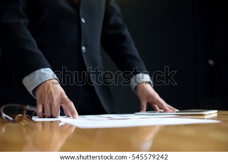 business man stand at the head of the table in boardroom black background Royalty-Free Stock Photo #545579242